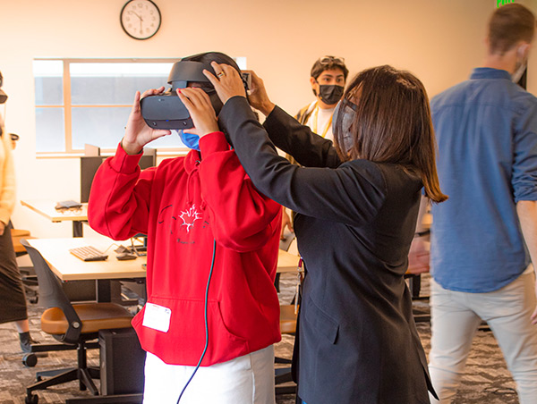 Nonny de la Peña helping a student with a VR headset