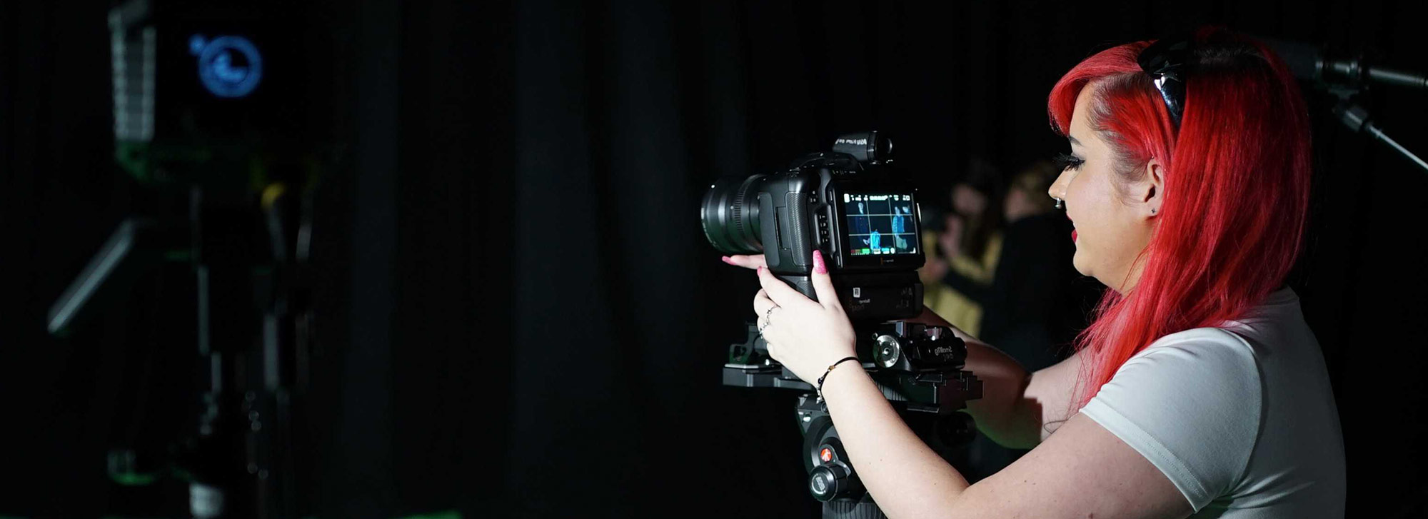 Student using a camera with green screen in the background